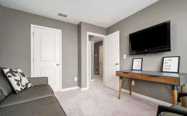 home office featuring baseboards, visible vents, and light colored carpet