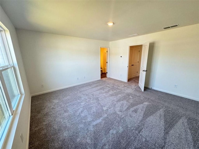 unfurnished bedroom featuring carpet flooring, visible vents, and baseboards