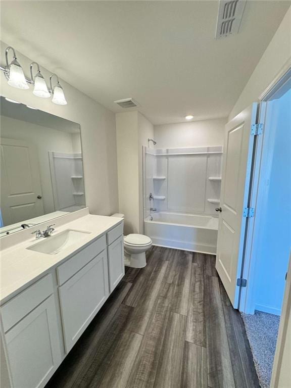 full bathroom featuring visible vents, toilet, wood finished floors, bathtub / shower combination, and vanity