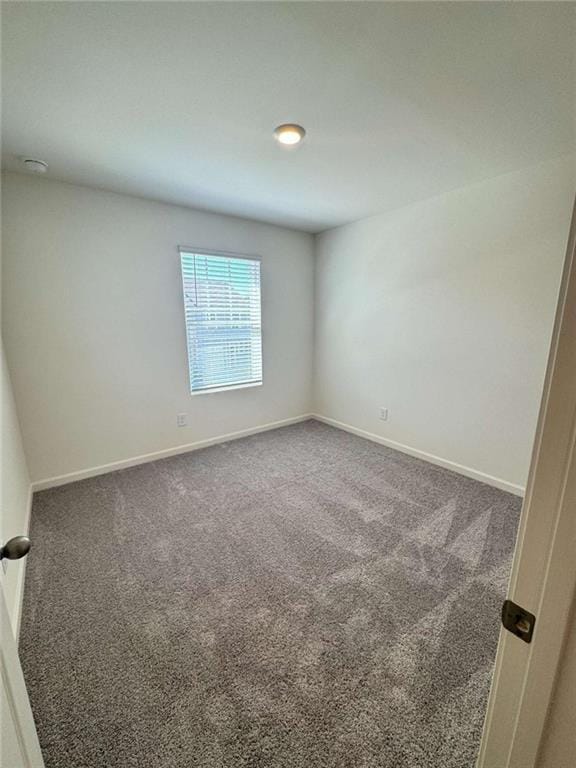 carpeted empty room with baseboards