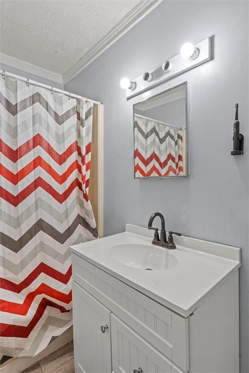 bathroom featuring vanity, crown molding, wood-type flooring, and a textured ceiling