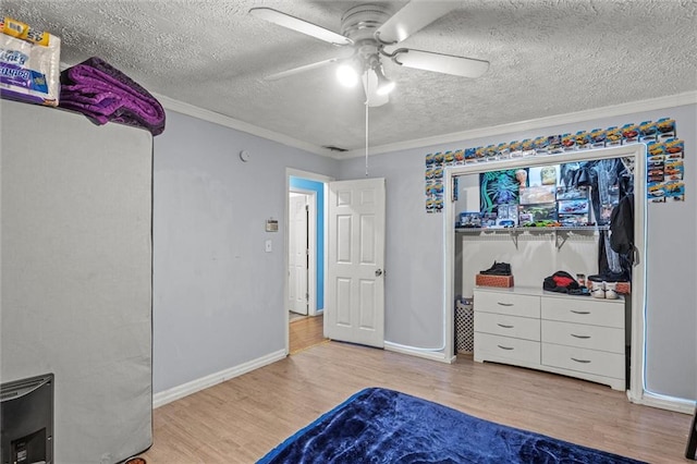 bedroom featuring ceiling fan, crown molding, a textured ceiling, and light wood-type flooring