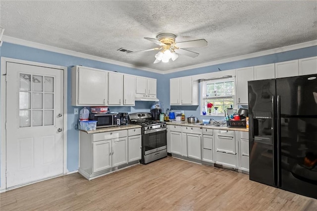 kitchen featuring appliances with stainless steel finishes, light hardwood / wood-style floors, and white cabinetry