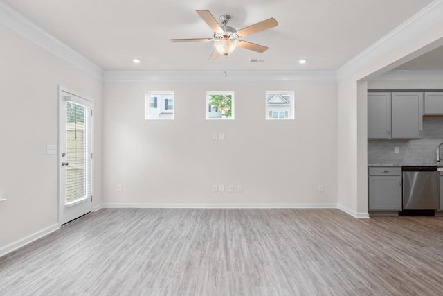 unfurnished living room with baseboards, visible vents, light wood finished floors, and ornamental molding