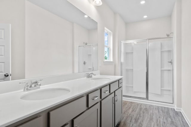 bathroom featuring a shower stall, wood finished floors, and a sink