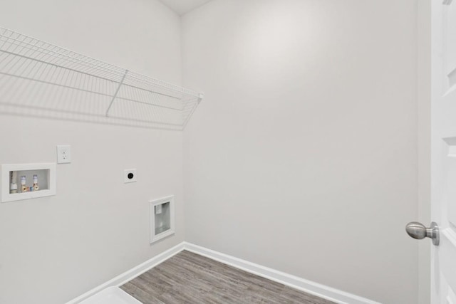 clothes washing area featuring baseboards, washer hookup, laundry area, wood finished floors, and electric dryer hookup