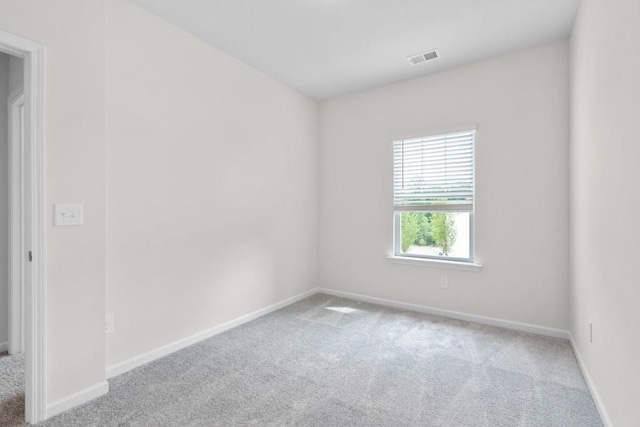 carpeted empty room with visible vents and baseboards