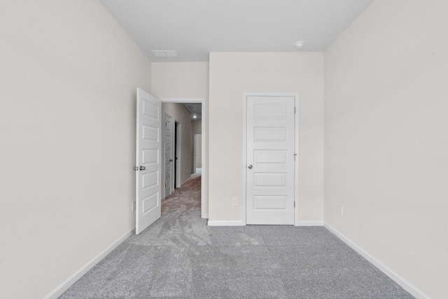 unfurnished bedroom with baseboards and carpet flooring