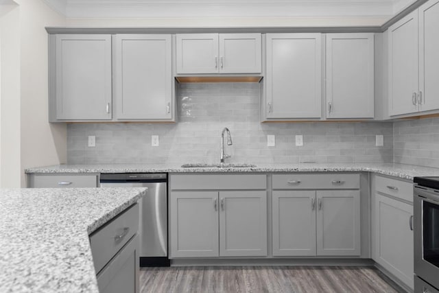 kitchen featuring appliances with stainless steel finishes, gray cabinetry, and a sink