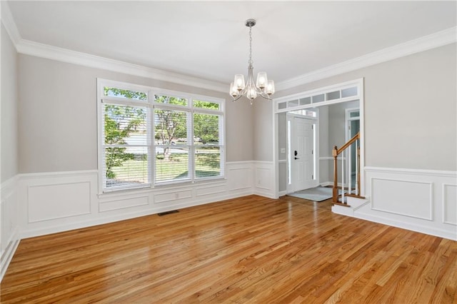 1755 Pinetree Pass Ln SW, Lilburn, GA 30047 - unfurnished dining area with a chandelier, crown molding, wainscoting, visible vents, and light wood finished floors