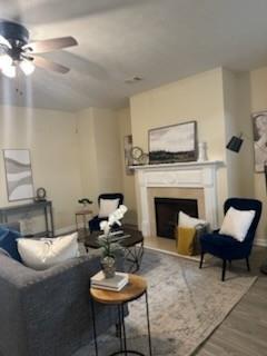 2991 Greyhawk Ln, Cumming, GA 30040 - living area with wood finished floors, a fireplace, and a ceiling fan