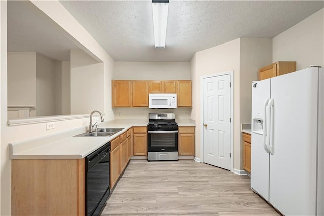 2991 Greyhawk Ln, Cumming, GA 30040 - kitchen with white appliances, light wood-style flooring, a textured ceiling, light countertops, and a sink
