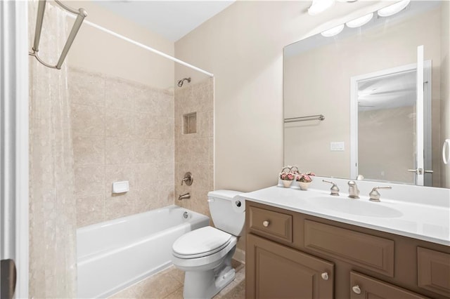 full bathroom with tile patterned flooring, vanity, tiled shower / bath combo, and toilet