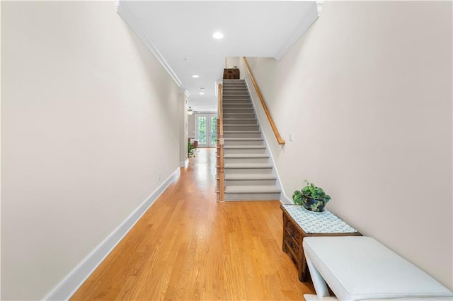 hallway with ornamental molding and hardwood / wood-style flooring