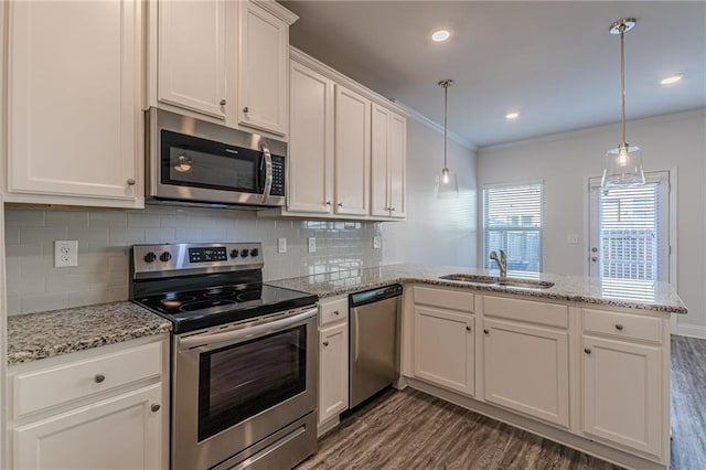 kitchen with pendant lighting, white cabinetry, sink, kitchen peninsula, and stainless steel appliances