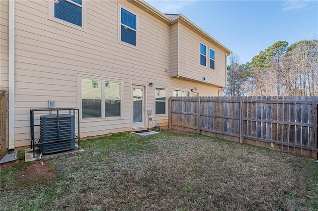 rear view of property featuring a yard and central air condition unit