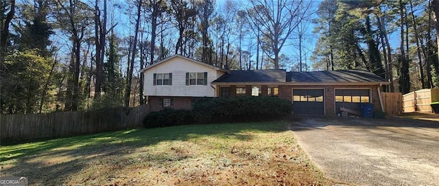 tri-level home featuring a front lawn and a garage