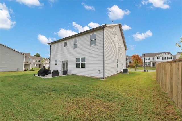 back of property with a patio, central AC unit, and a lawn