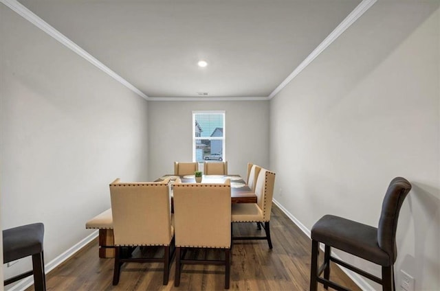 dining area featuring dark wood-type flooring and ornamental molding