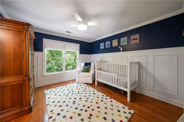 1360 Edmund Ct NE, Atlanta, GA 30306 - bedroom featuring a decorative wall, wood finished floors, ornamental molding, wainscoting, and a ceiling fan