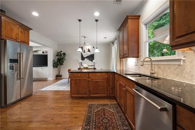 1360 Edmund Ct NE, Atlanta, GA 30306 - kitchen featuring stainless steel appliances, a peninsula, tasteful backsplash, dark wood-style flooring, and hanging light fixtures