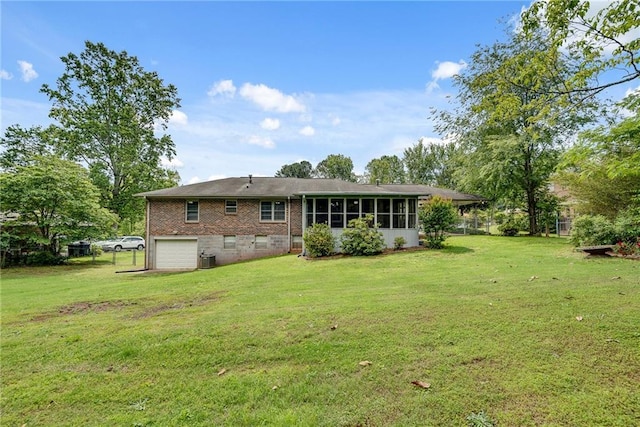 2653 Elkhart Cir SW, Marietta, GA 30064 - back of property featuring brick siding, a garage, a yard, and a sunroom