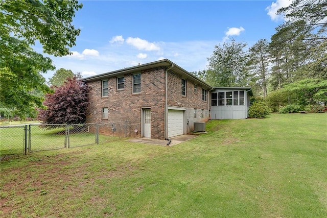2653 Elkhart Cir SW, Marietta, GA 30064 - rear view of property with a gate, an attached garage, a sunroom, brick siding, and central air condition unit