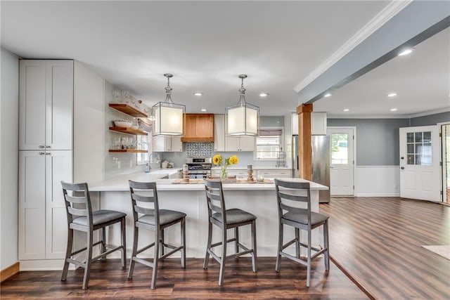 2653 Elkhart Cir SW, Marietta, GA 30064 - kitchen featuring stainless steel appliances, ornamental molding, a peninsula, light countertops, and dark wood finished floors