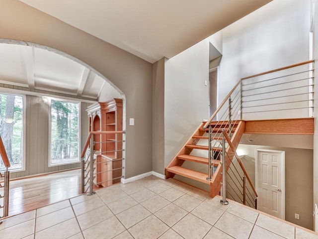 3771 Club Dr NW, Kennesaw, GA 30144 - staircase featuring tile patterned floors, arched walkways, and baseboards