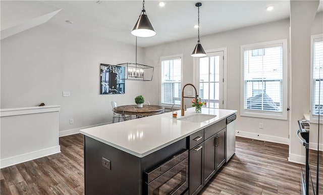 kitchen with light countertops, stainless steel dishwasher, dark wood-type flooring, a sink, and black microwave