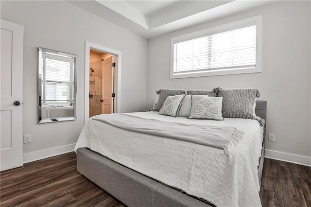 bedroom with multiple windows, dark wood finished floors, and baseboards