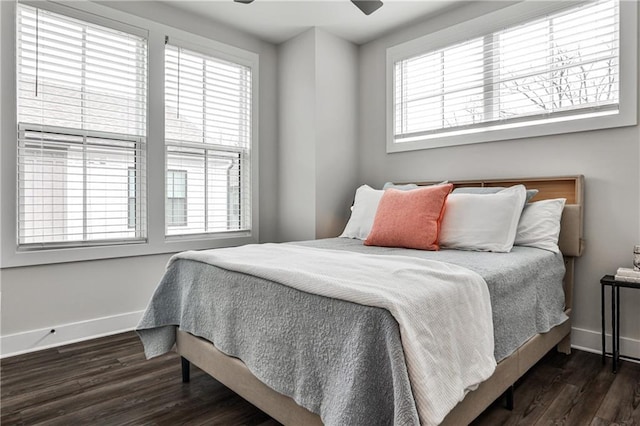 bedroom featuring multiple windows, baseboards, and wood finished floors