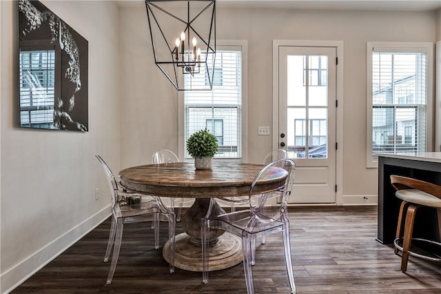 dining area featuring a notable chandelier, dark wood finished floors, and baseboards