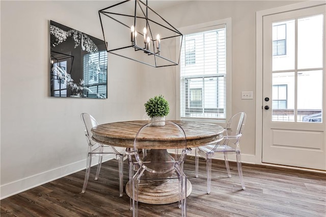 dining room with an inviting chandelier, baseboards, and wood finished floors