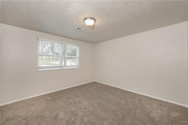 carpeted spare room featuring a textured ceiling