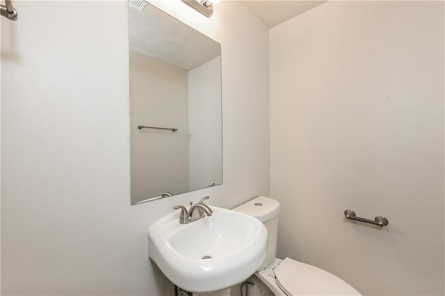 bathroom featuring sink, toilet, and a textured ceiling