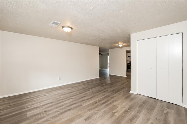 interior space with hardwood / wood-style floors, a closet, and a textured ceiling