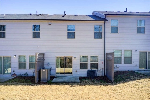 rear view of property with central air condition unit, a yard, and a patio