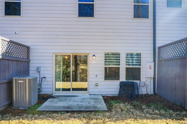 back of house featuring fence, central AC, and a patio