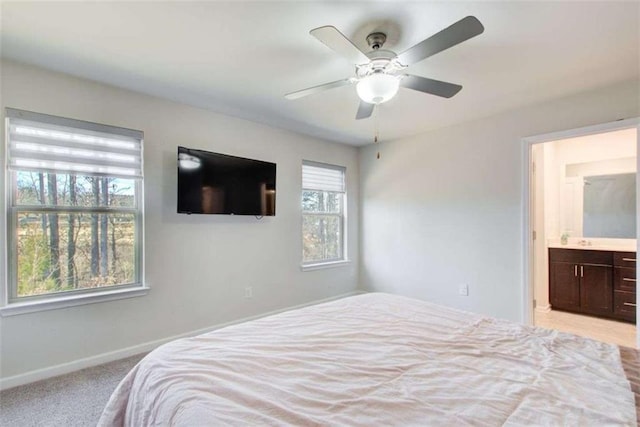 bedroom featuring a ceiling fan, baseboards, connected bathroom, and light colored carpet