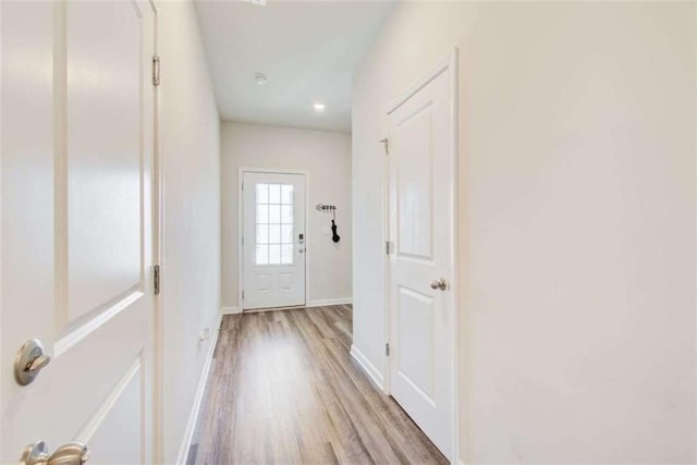 entryway with baseboards and light wood finished floors