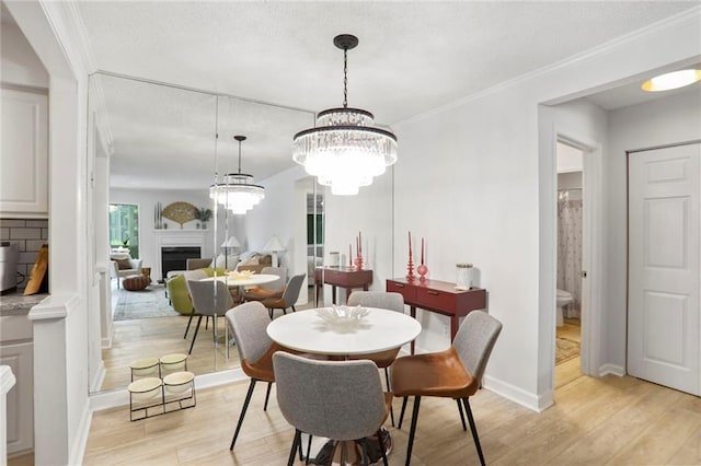 1303 Wingate Way, Atlanta, GA 30350 - dining area with light wood finished floors, a fireplace, baseboards, crown molding, and a chandelier