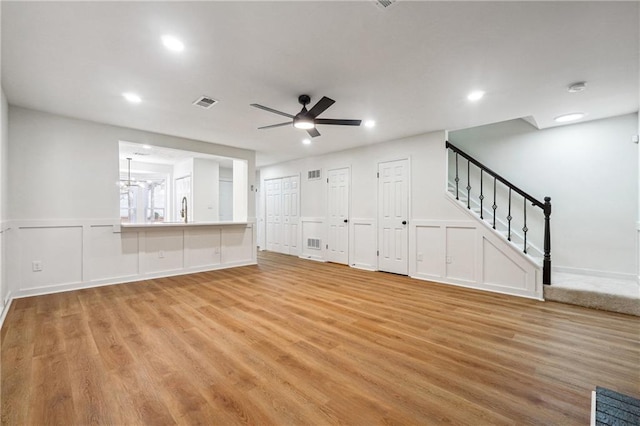 unfurnished living room with ceiling fan and light hardwood / wood-style flooring