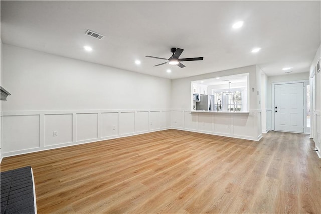 unfurnished living room with ceiling fan and light hardwood / wood-style flooring