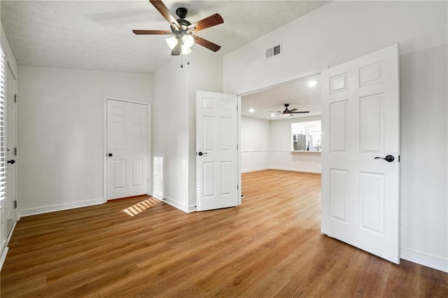 spare room featuring ceiling fan, hardwood / wood-style floors, a healthy amount of sunlight, and lofted ceiling