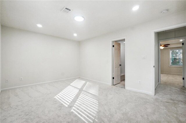 empty room featuring ceiling fan and light colored carpet