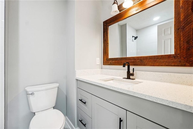 bathroom with vanity, toilet, and a shower