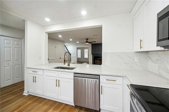 kitchen with stainless steel appliances, light hardwood / wood-style flooring, white cabinetry, and sink