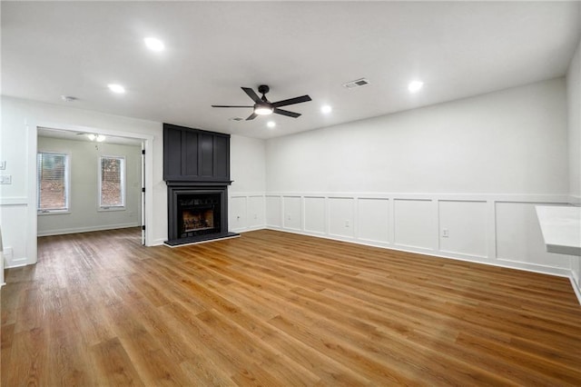 unfurnished living room featuring a fireplace, ceiling fan, and hardwood / wood-style floors