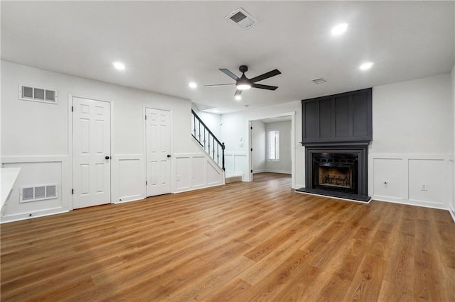 unfurnished living room with a fireplace, light hardwood / wood-style flooring, and ceiling fan